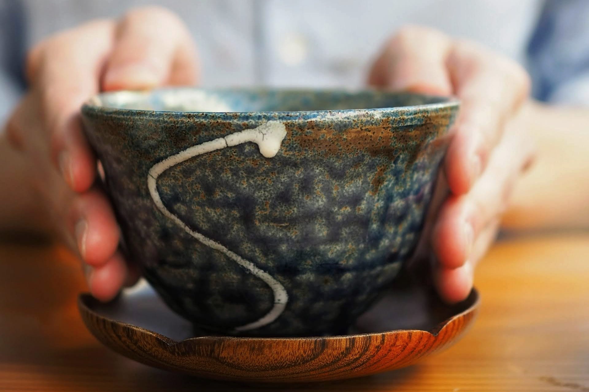 Handheld ceramic bowl revealing rim thickness, glaze variation, and balance, used as a case study for perceptual clarity.
